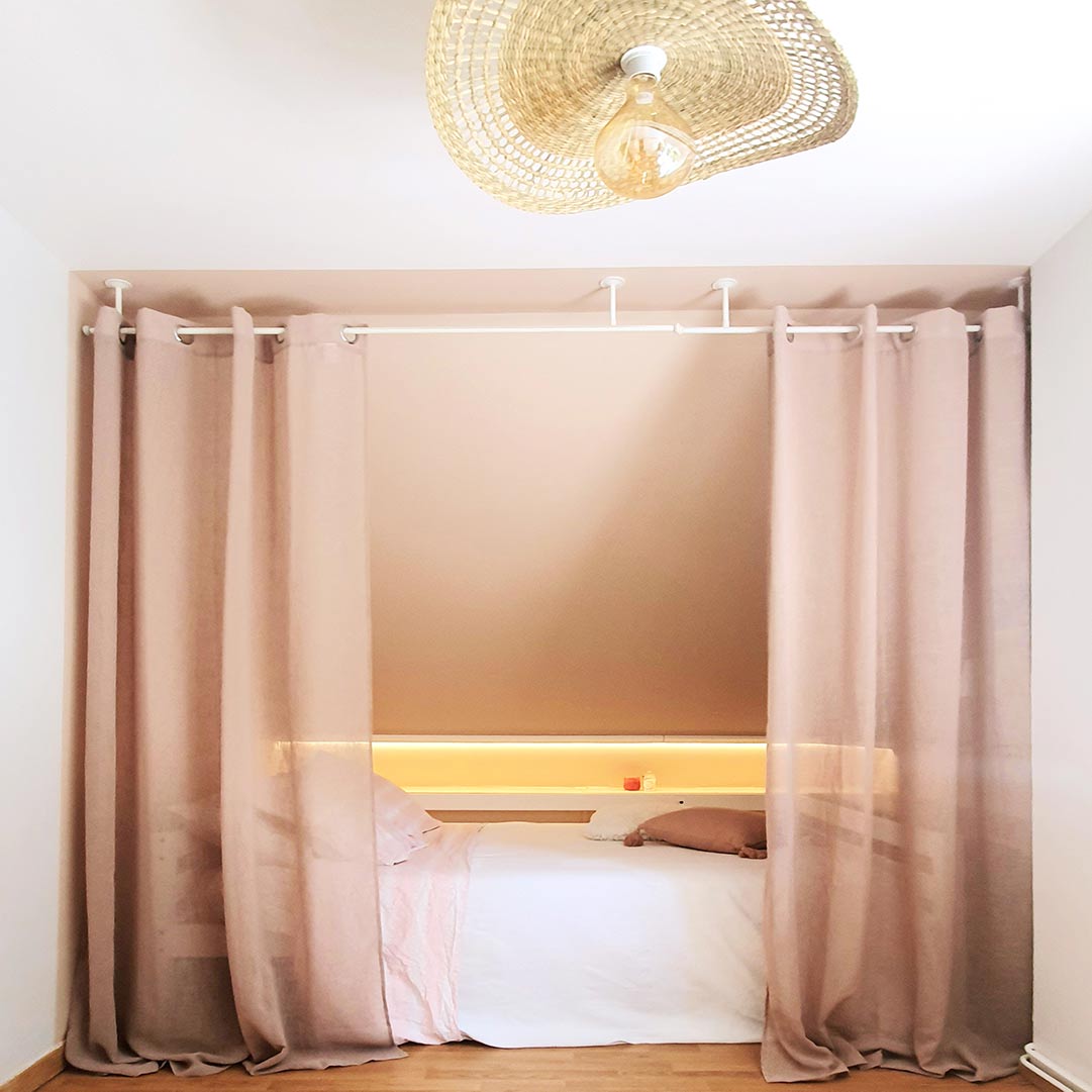 Coin chambre sous combles avec rideaux et éclairage LED chaleureux, espace cosy pour adolescente